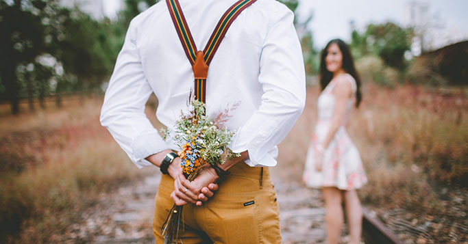 Mann mit Blumen und Frau