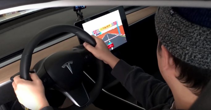 Fahrer spielt Autorennspiel in einem Auto von Tesla