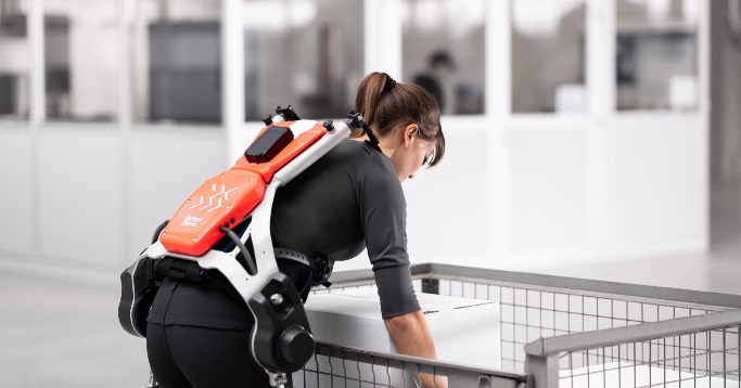 Frau trägt mit einem Exoskelett von German Bionic eine Kiste