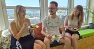 Drei Personen essen gemeinsam Kuchen und haben Spaß dabei.