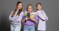 Eine Frau hält das Trendbuch Handelskraft 2025 und 2 Frauen schauen über ihre Schulter.