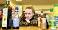 Frau sitzt vor verschiedenen Zutaten und guckt nachdenklich.