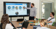 Präsentation zu Large Language Models im Besprechungsraum vor sitzendem Team.