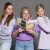 Eine Frau hält das Trendbuch Handelskraft 2025 und 2 Frauen schauen über ihre Schulter.